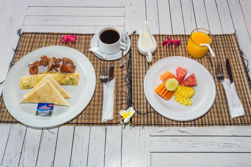un tavolo con due piatti di cibo e una tazza di caffè di Bukit Taman Cottages a Nusa Lembongan