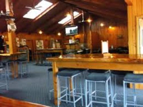 a large room with a bar with stools at Noah's Boutique Accommodation Moeraki in Moeraki