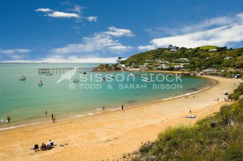 a group of people on a beach with a pier at Noah's Boutique Accommodation Moeraki in Moeraki