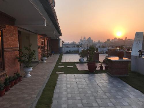 a patio with a view of the city at sunset at DOM Himalaya Hotel in Kathmandu