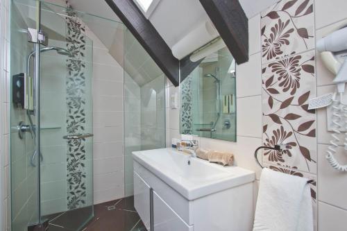 een badkamer met een wastafel en een douche bij Knights Inn in Auckland