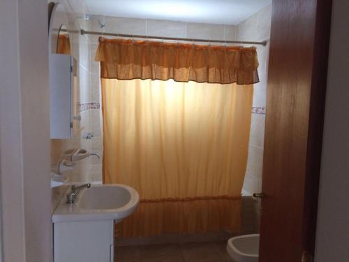 un bagno con lavandino e tenda da doccia di Altas Mareas a Las Grutas