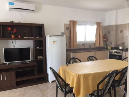 una cucina con tavolo con sedie e frigorifero di Altas Mareas a Las Grutas