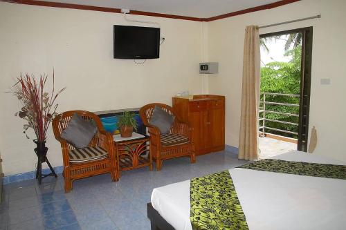 a bedroom with two beds and a tv on the wall at Seaworld Guesthouse in Ao Nang Beach