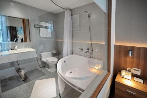 a bathroom with a tub and a toilet and a sink at Melissa Hotel Nha Trang in Nha Trang