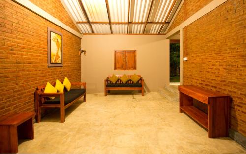 a room with two benches and a brick wall at Hide Yala in Tissamaharama