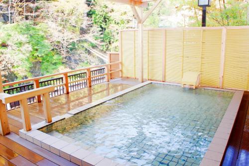 a swimming pool on a balcony with a bench at Ichiryukaku Honkan in Nikko
