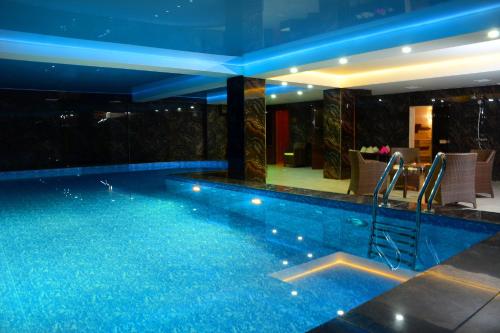 a swimming pool with blue lights in a building at Hotel Arai Plaza in Taraz