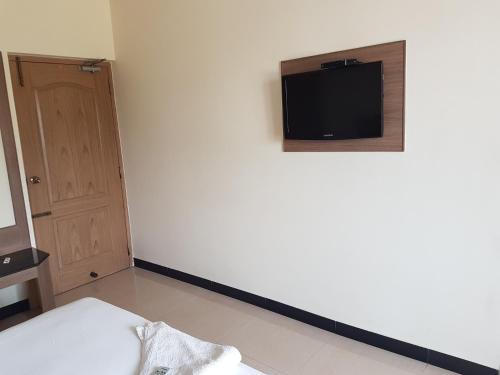 a room with a white wall with a tv on the wall at SK Residency in Coimbatore