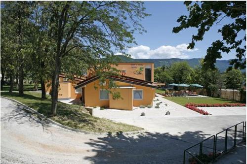 a building on a street next to a park at Garni Hotel Siesta in Nova Gorica