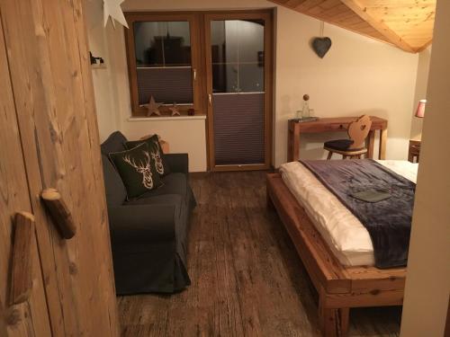 a bedroom with a bed and a chair and a desk at Hotel zum Urviech -Erwachsenenhotel- in Ehrwald