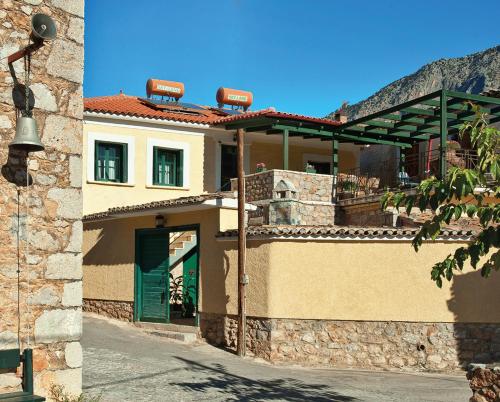 una casa con una puerta verde y una montaña en Alexandros Pension, en Delfos