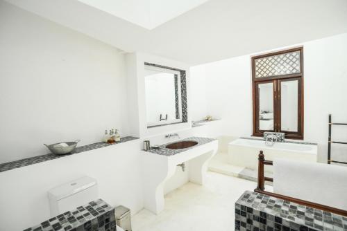 a white bathroom with two sinks and a tub at Villa 32 Middle Street in Galle