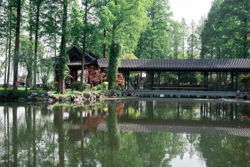 a pavilion and a pond in a park at Zhejiang Xizi Hotel in Hangzhou