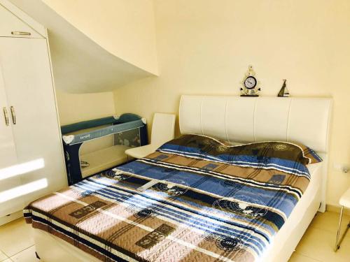 a bedroom with a bed with a clock on top of it at VILLA 16L in Kalecik