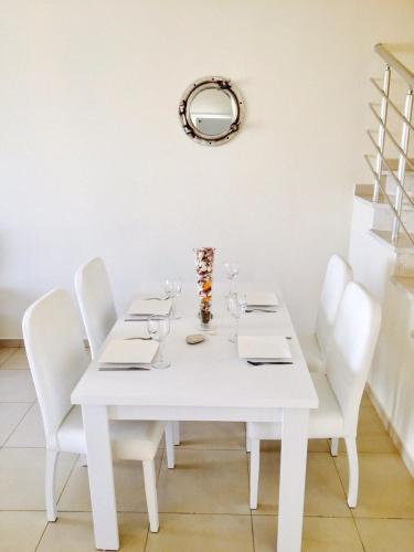 a white table with white chairs and a mirror at VILLA 16L in Kalecik