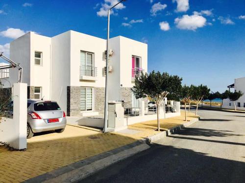 a white house with a car parked in front of it at VILLA 16L in Kalecik