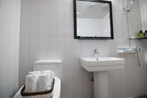 a bathroom with a sink and a toilet and a mirror at Lium Spa Hostel in Yeosu