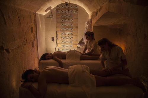 a group of people laying on beds in a tunnel at Principe Relais Suite & Spa in Gravina in Puglia