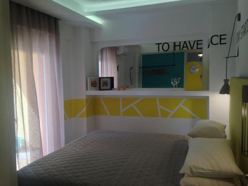 Dormitorio con cama y espejo con las palabras en The Orange Apartments, en Tesalónica