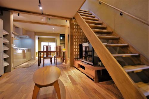 a living room with a staircase and a chair at Kyo-machiya Flower Inn Hanayo in Kyoto