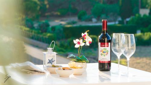 una bottiglia di vino e due bicchieri su un tavolo di Lido Sole a Gallipoli
