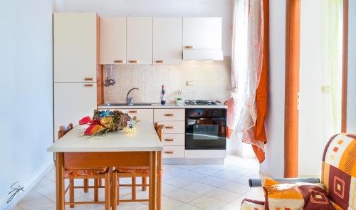 ガリポリにあるLido Soleの白いキャビネットと花のテーブル付きのキッチンが備わります。