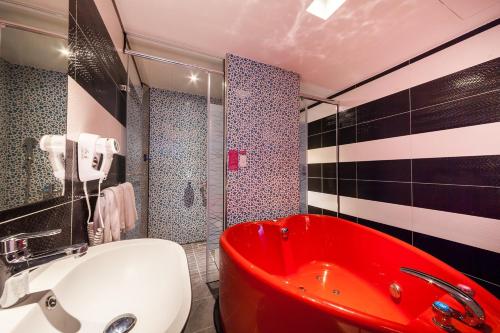 a bathroom with a red tub and a red sink at 響悅汽車旅館 in Xinwu