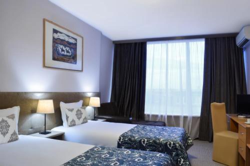 a hotel room with two beds and a window at Rila Hotel Sofia in Sofia