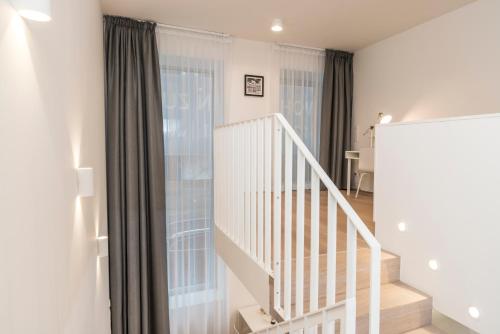 a white staircase in a room with a window at Luxury Suites Liechtenstein in Vienna