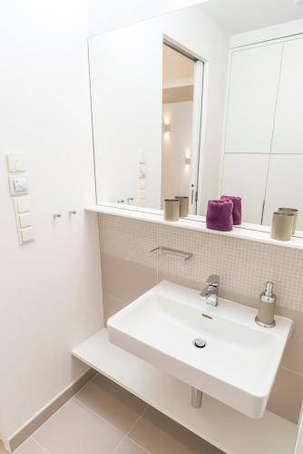 a bathroom with a white sink and a mirror at Luxury Suites Liechtenstein in Vienna