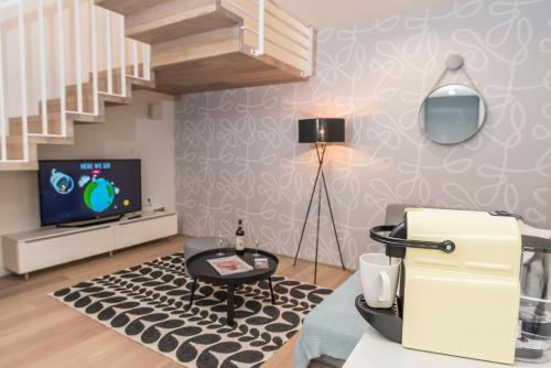 a living room with a staircase and a television at Luxury Suites Liechtenstein in Vienna