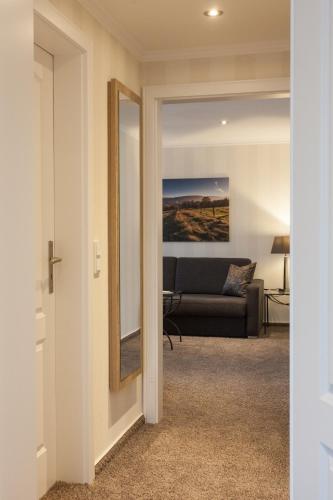 a living room with a couch and a mirror at Hotel Garni Fürst von Waldeck in Willingen