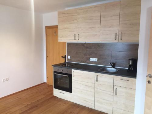 eine Küche mit Holzschränken und einer Spüle in der Unterkunft Privatzimmervermietung Wiederkehr in Altenmarkt im Pongau