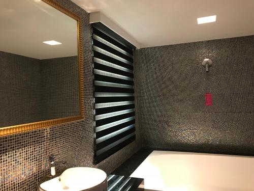 a bathroom with a tub and a sink and a mirror at 響悅汽車旅館 in Xinwu