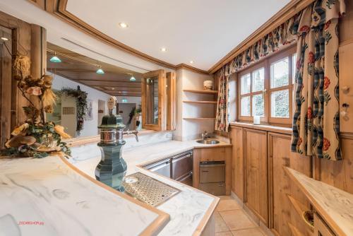a kitchen with wooden cabinets and a sink at Almliesl HOLL-556 in Hollersbach im Pinzgau