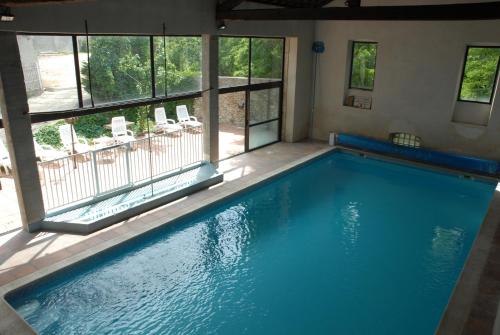 a large swimming pool in a house with a window at Hotel de l'Europe in Joyeuse