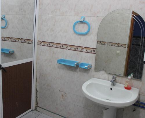 La salle de bains est pourvue d'un lavabo et d'un miroir. dans l'établissement Hotel Souika, à Chefchaouen