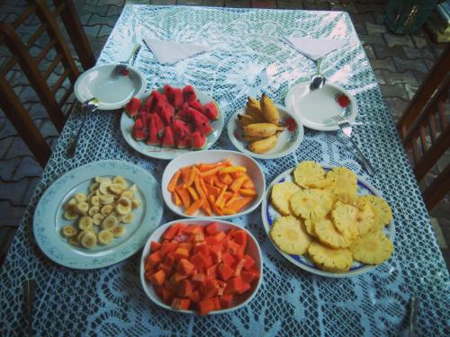 a table with bowls of different types of fruits and vegetables at Radha Tourist Home in Polonnaruwa
