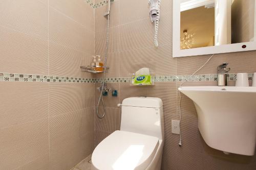 a bathroom with a white toilet and a sink at Pretty Flowers Homestay in Ji'an