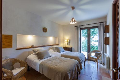 a hotel room with two beds and a mirror at Mansion Ses Oliveres in S'Horta