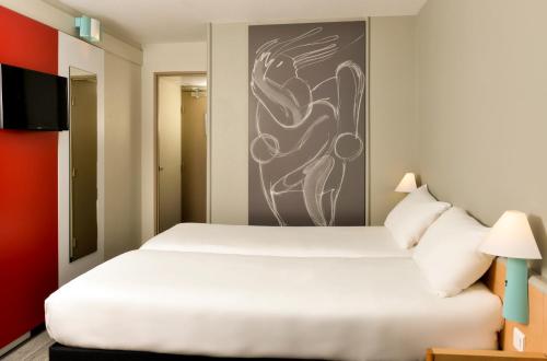 Un pat sau paturi într-o cameră la ibis Nemours