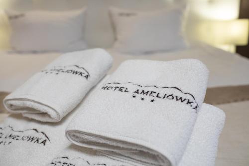 three towels sitting on top of a table at Hotel Ameliówka in Masłów