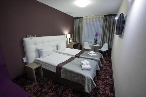 um quarto de hotel com uma cama, uma mesa e cadeiras em Hotel Ameliówka em Masłów