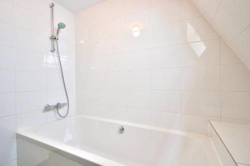 a white bath tub in a white tiled bathroom at 2 BEDROOM CITY CENTER TERRACE in Amsterdam