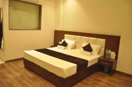 a bedroom with a large bed with white sheets and pillows at Lotus Grand Akm in Kālka