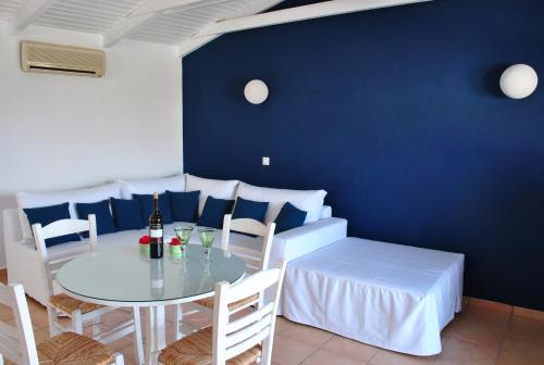 a dining room with a white table and chairs at LIVAS Apartment in Ierápetra