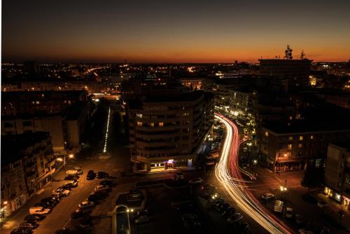 a city lit up at night with cars at Hotel Prahova Plaza in Ploieşti