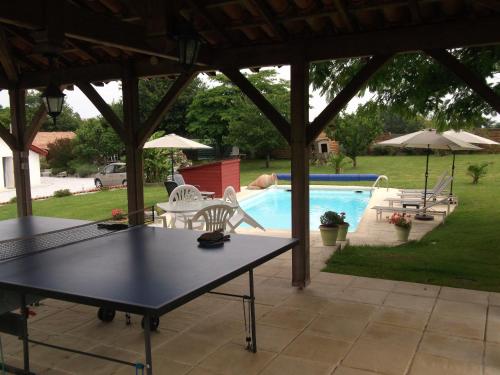 a patio with a table and chairs and a pool at la forge de Clermont in Clermont