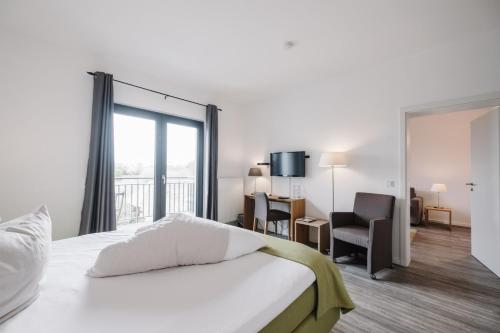 a bedroom with a bed and a desk and a chair at Jordan's Untermühle in Köngernheim